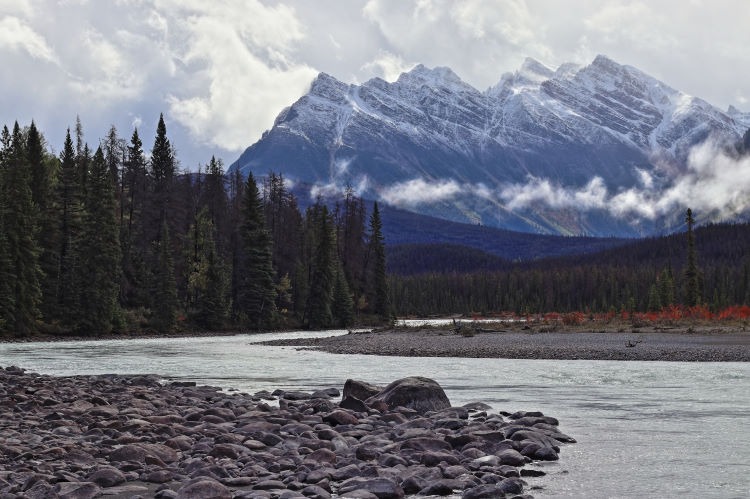 Landscape photograph of the Athabasca River backed by the Dragon Peaks of Catacombs Mountain