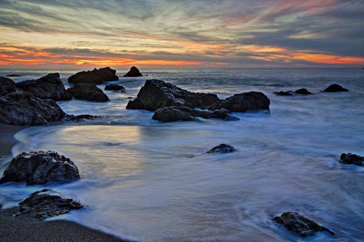 Long exposure seascape photograph of the sunset over a rocky North Pacific Beach