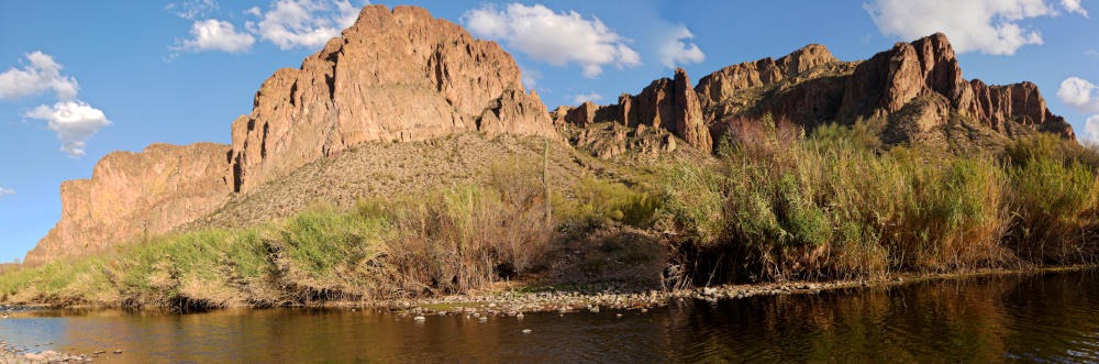 Wide angle panorama of mountains in the Superstition Range of southern Arizona. The rock is front lit at the left but shifts to side lighting on the right.